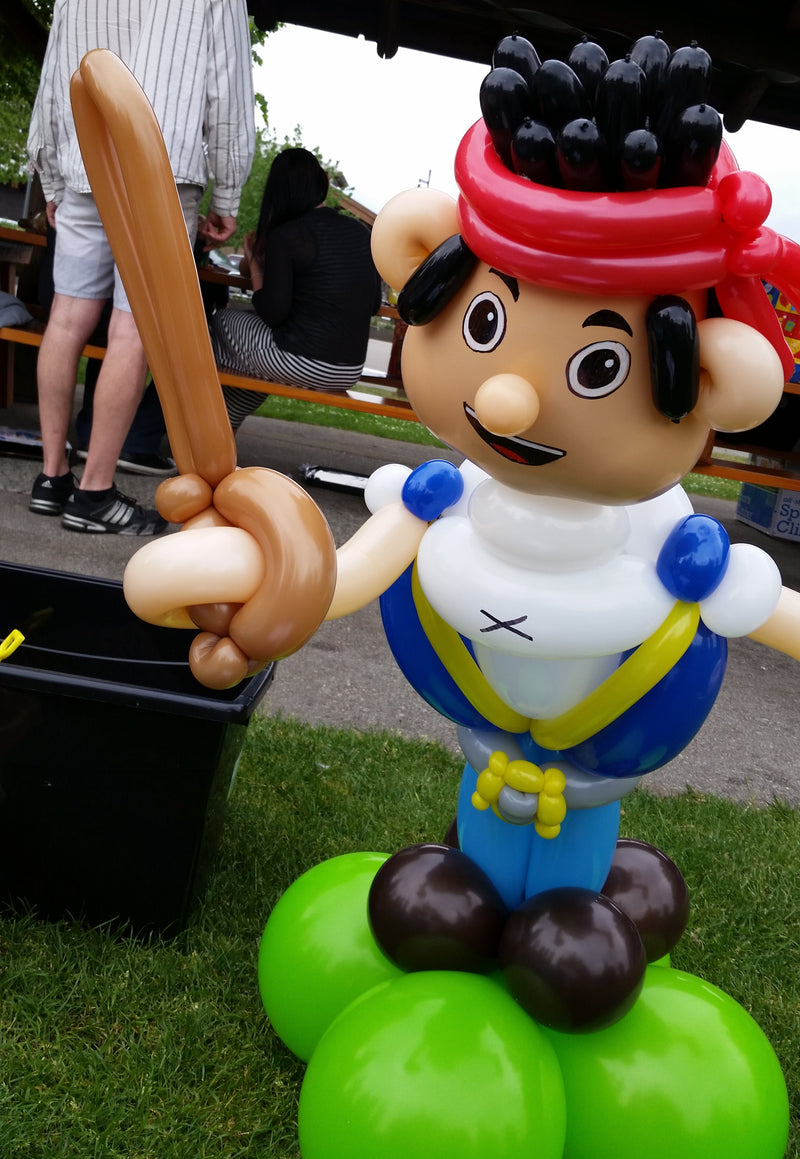 Balloon sculpture of a pirate character with a baseball bat on a grassy background24