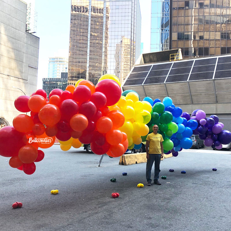 man with large pride colour balloon arch outdoors16