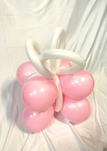 Load image into Gallery viewer, A festive balloon creation shaped like a gift box with pink balloons forming the base and white twisted balloons creating a ribbon bow on top