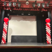 Load image into Gallery viewer, balloon columns with red and white balloons on stage
