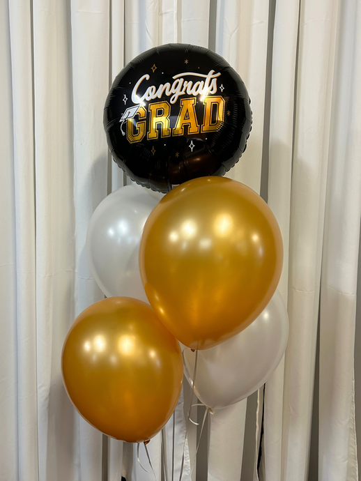 grad 100% foil balloon on top with gold and white balloons