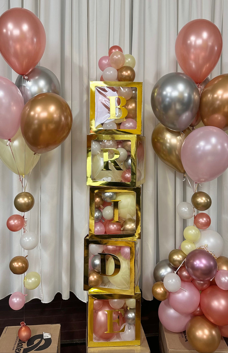 Decorative setup with balloons and gold letter blocks spelling 'LOVE' against a curtain background.23