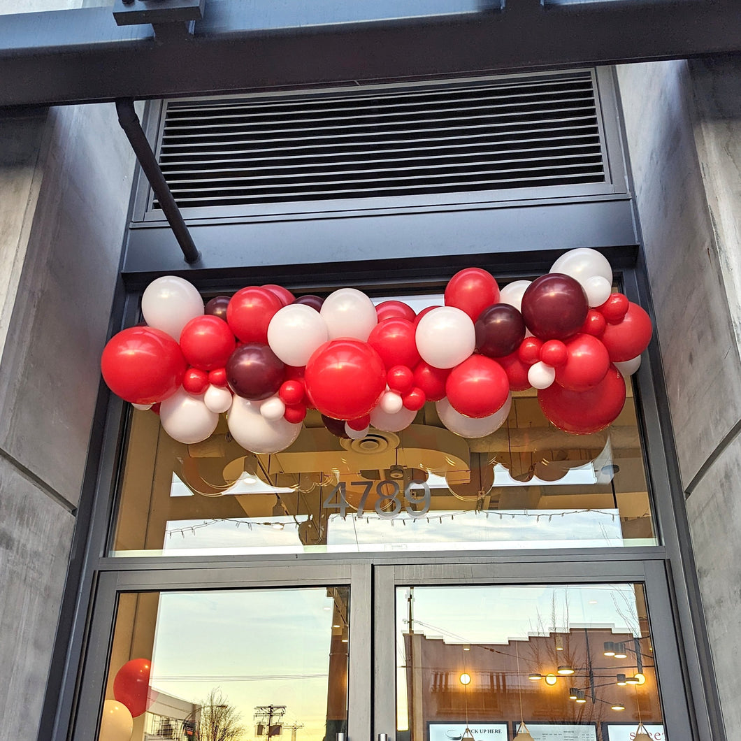 Red and white balloon garland outdoors